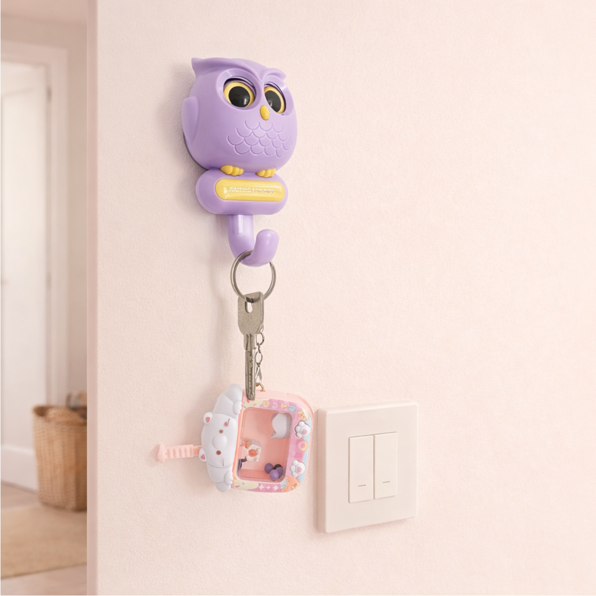 Purple owl-shaped wall hook holding keys, cute pastel key holder for entryway and home organization.