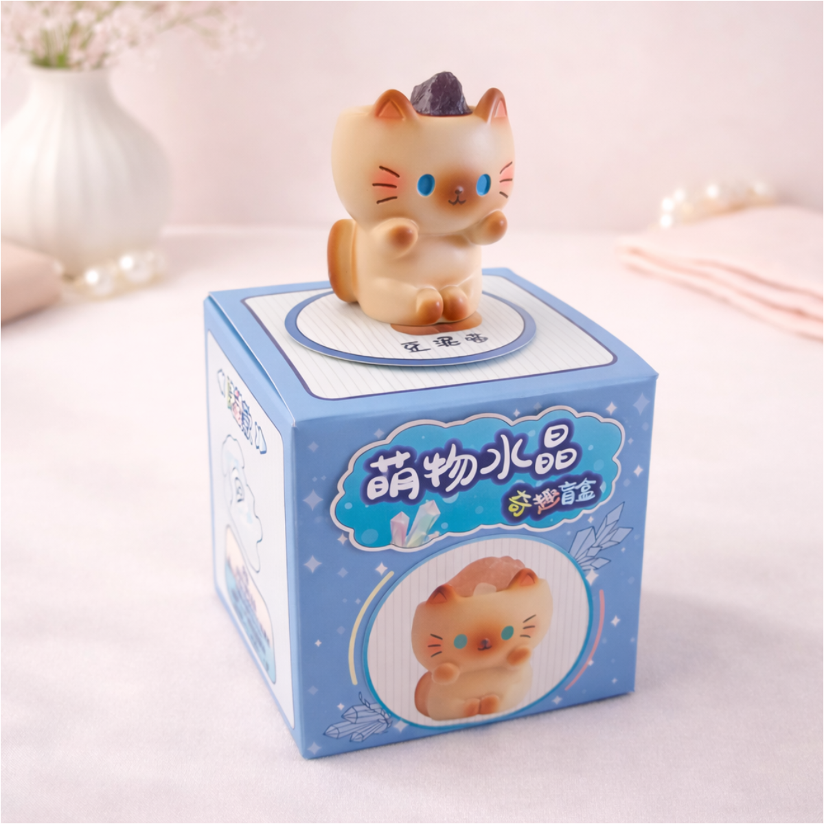 Cute cat figurine holding a stone on display box, kawaii collectible animal decor for desk and shelves.