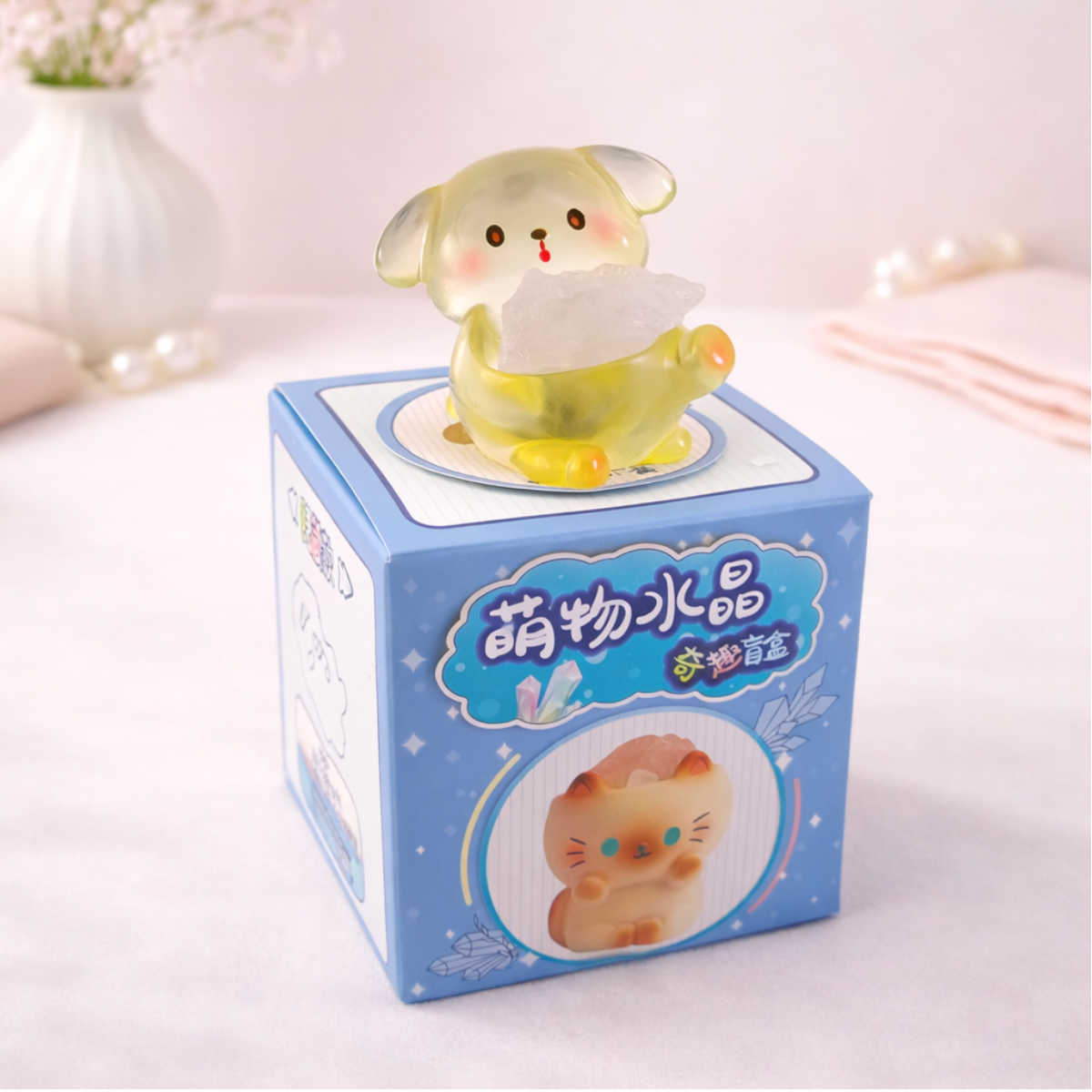 Cute mystery dog figurine holding a crystal on display box, kawaii animal collectible for desk and shelf decor.