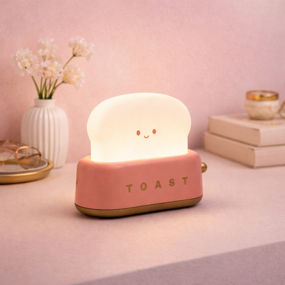 Red toaster-shaped desk lamp with smiling face, cute pastel LED night light for desk or bedside decor.