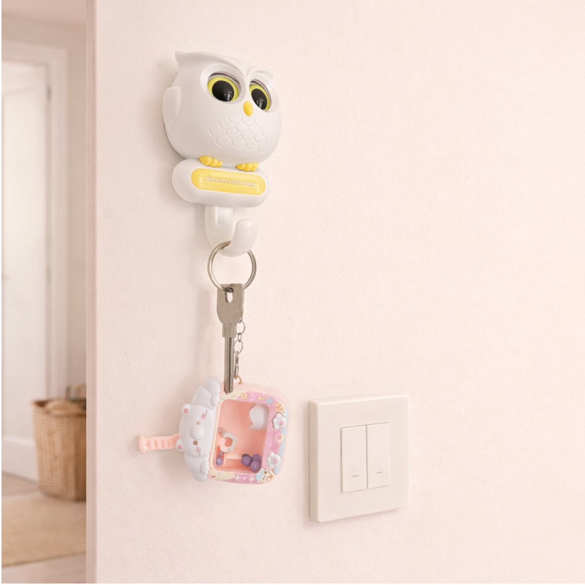 White owl-shaped wall hook holding keys, cute pastel key holder for entryway and home organization.